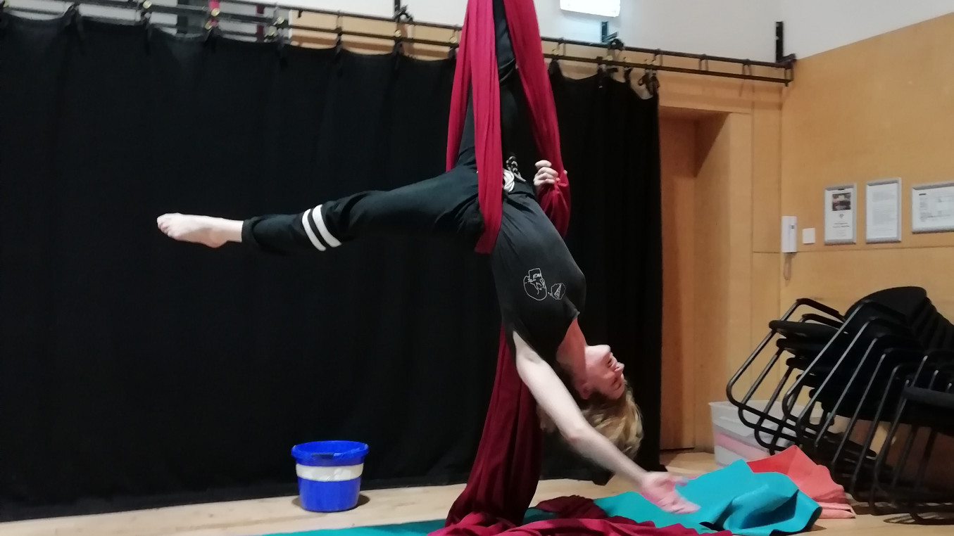 Smiling woman in modified ankle hang on silks