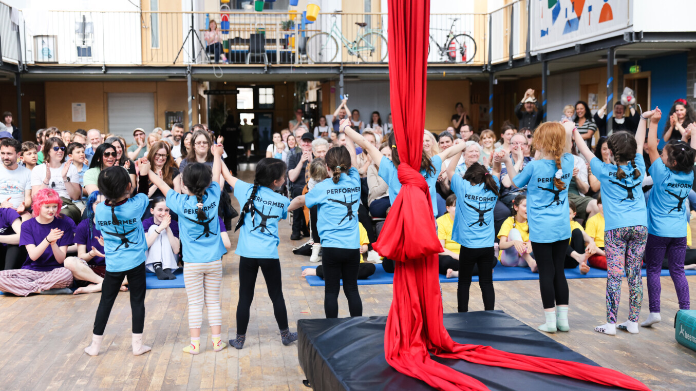 A group of young performers take a bow in front of an audience
