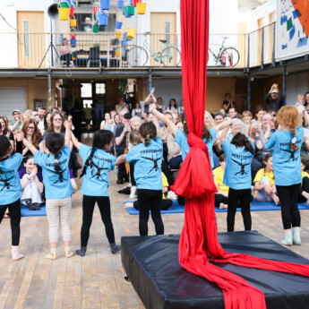 A group of young performers take a bow in front of an audience